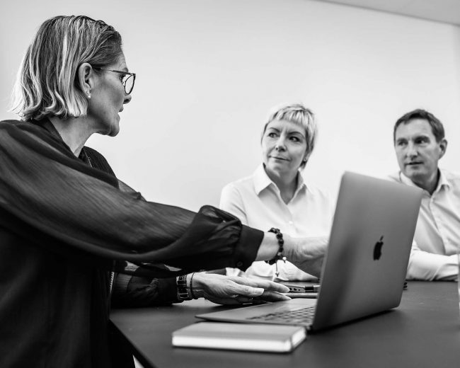To kvinder og en mand der taler om professionel IT-rådgivning